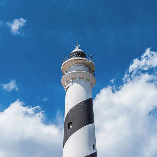Torre do farol de Favàritx, com faixas pretas e brancas, vista de baixo.